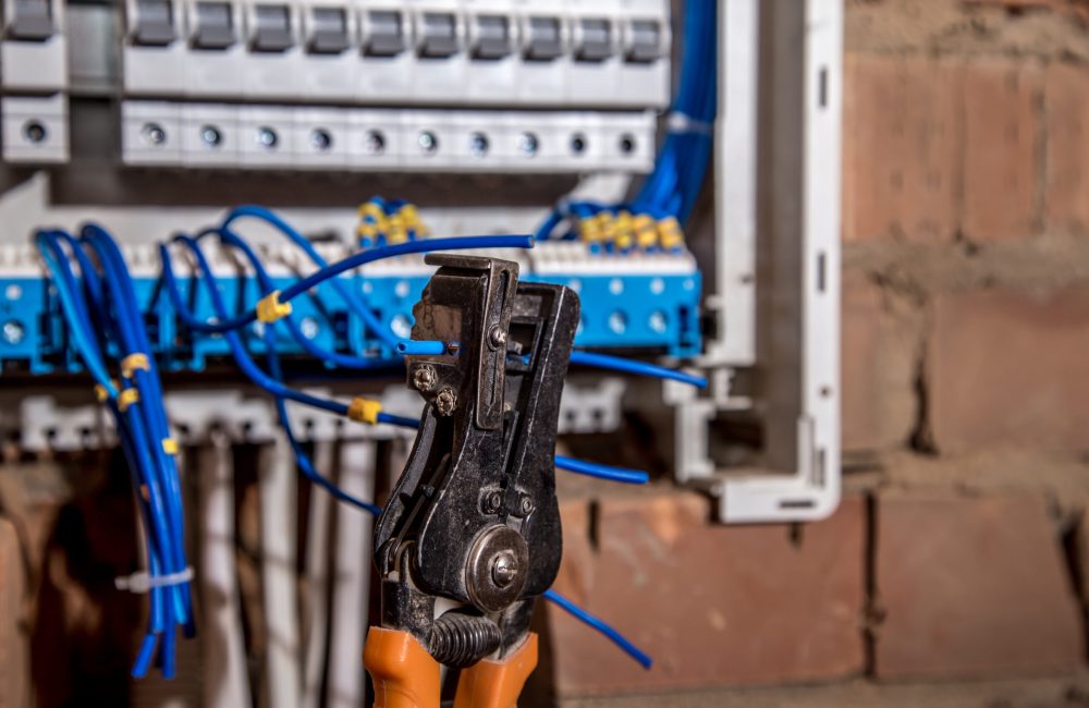 the Assembly of the electrical panel, electrician job, a robot with wires and circuit breakers, tools